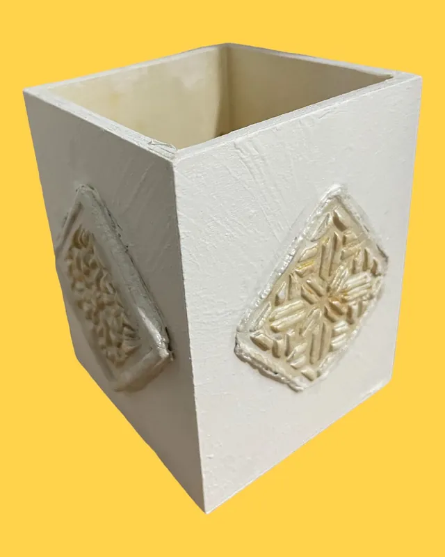 White pen holder decorated with a raised clay tile